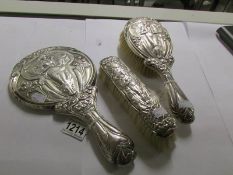 An Edwardian 3 piece silver dressing table set comprising hand mirror and 2 brushes featuring an