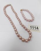 A row of pink pearls and a matching bracelet.