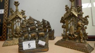 A pair of brass ship book ends and a pair of brass bear with beehive ornaments.