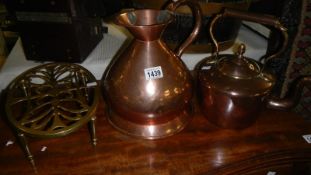 A copper kettle, a copper jug and a brass trivet,
