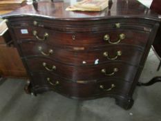 A Georgian serpentine fronted veneered chest of drawers.