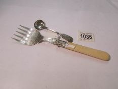 A silver fish serving fork and a large silver mustard spoon.