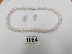 A white Honora pearl necklace with clip earrings.