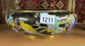 A large cloissonne bowl decorated with birds.