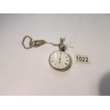 A silver pocket watch on a yellow metal chain (crack to dial).