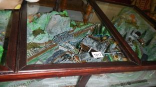 A cased static diorama of narrow gauge railway set in a quarry.