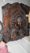 A carved wood panel depicting an Indian Deity.
