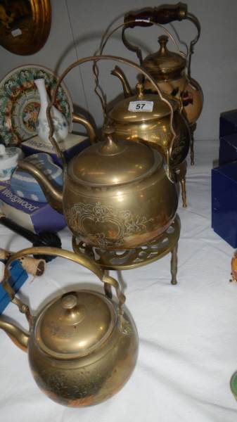 3 brass kettles, a floral decorated kettle and 3 brass trivets.