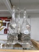 A metal 3 bottle tantalus with 3 decanters (missing one stopper).