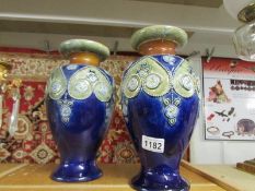 A pair of Royal Doulton vases, signed MH and MB, base 3306.