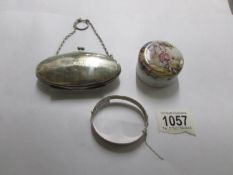 An engraved silver bangle, a silver purse and a ceramic trinket box.