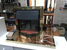 A coal effect electric fire with brass and copper base/fender