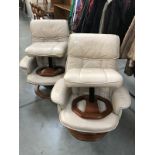 A pair of leather swivel chairs with foot stools