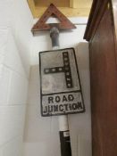 A vintage aluminium junction road sign with warning triangle and on pole.