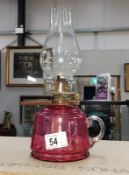 A Victorian cranberry glass finger oil lamp