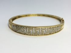 A 9ct gold bracelet set diamonds in a Greek key design.