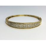 A 9ct gold bracelet set diamonds in a Greek key design.