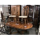 An Ercol dining table with 5 chairs and 1 carver.