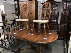An Ercol dining table with 5 chairs and 1 carver.