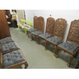 A set of 8 carved hard wood chairs with drop in seats.