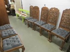 A set of 8 carved hard wood chairs with drop in seats.