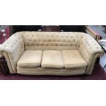 A fabric covered chesterfield sofa