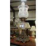 A cast metal base oil lamp with etched shade