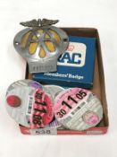 A quantity of old tax discs and a RAC members badge in empty box and an AA car badge