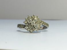 A diamond cluster ring with 18ct white gold crossover shank. Approximate total carat weight 1.