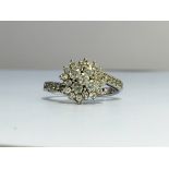 A diamond cluster ring with 18ct white gold crossover shank. Approximate total carat weight 1.