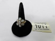 An opal cluster ring in 9ct yellow gold with 7 cabochon opals arranged as a flower head.