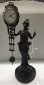 A bronzed spelter figurine mystery swinging clock.