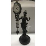 A bronzed spelter figurine mystery swinging clock.