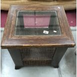A dark wood stained & wicker coffee table with drawer & glass top