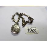 A Victorian silver locket on decorative unmarked white metal chain.