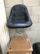 A wire frame chair with buttoned leather seat