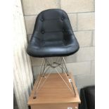 A wire frame chair with buttoned leather seat