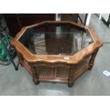 A teak effect octagonal coffee table with bevelled glass top