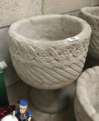 A Mayan circular planter decorated with aztec design