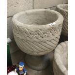 A Mayan circular planter decorated with aztec design