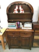 An arch topped dresser with folded linen carvings