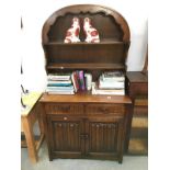 An arch topped dresser with folded linen carvings