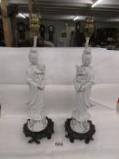 A pair of ceramic table lamps in the form of Chinese figures, need re-wiring.