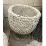 A Mayan circular planter decorated with aztec design