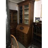 An oak bureau book case with carved panel.