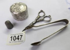 A silver thimble, a continental silver pill box, a pair of Victorian scissors and EPNS sugar tongs.