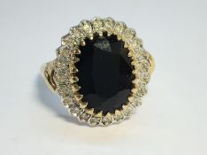 A 9ct gold ring set with 7ct sapphire surrounded by pave diamonds