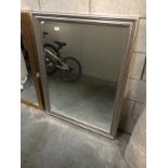 A large beveled mirror with silver coloured frame (34 inches wide,