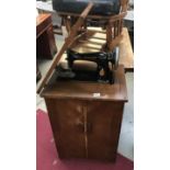 A vintage Singer sewing machine in oak cabinet