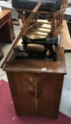 A vintage Singer sewing machine in oak cabinet